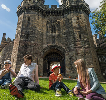 Family sitting outside Lancaster Castle