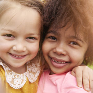 children hugging and looking at the camera