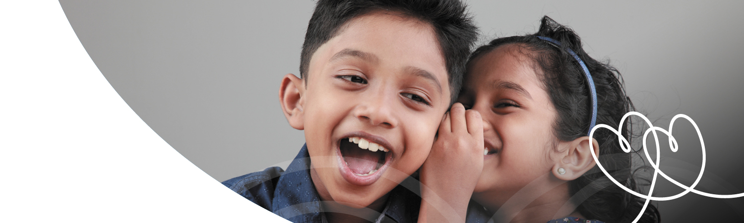 Foster child whispering to other foster child and laughing